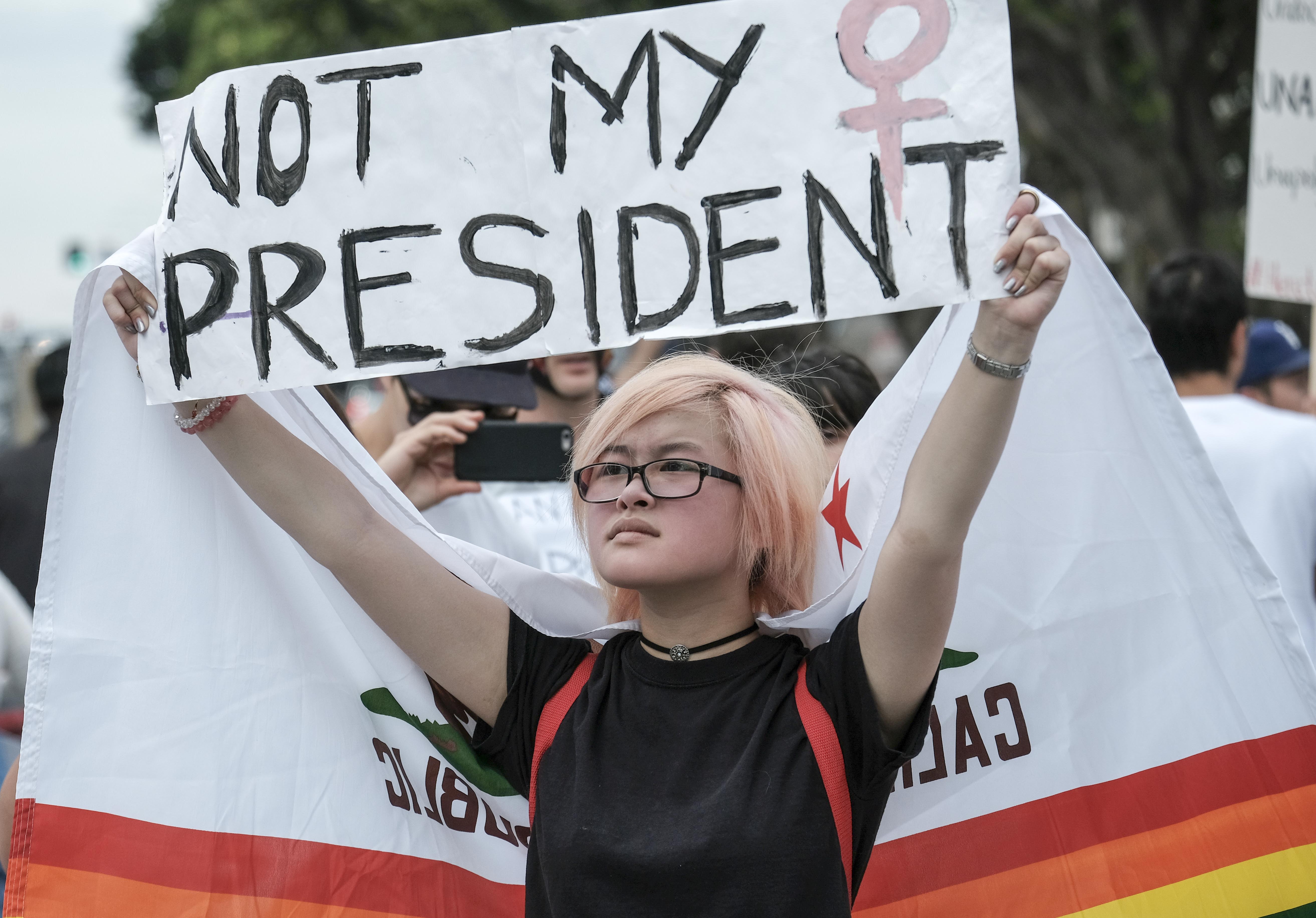 Demonstrators gather outside the Edward Roybal Federal Building to protest against US President-elect Donald Trump in Los Angeles on November 12, 2016. Americans spilled into the streets Saturday for a new day of protests against Donald Trump, even as the president-elect appeared to back away from the fiery rhetoric that propelled him to the White House. / AFP PHOTO / RINGO CHIU