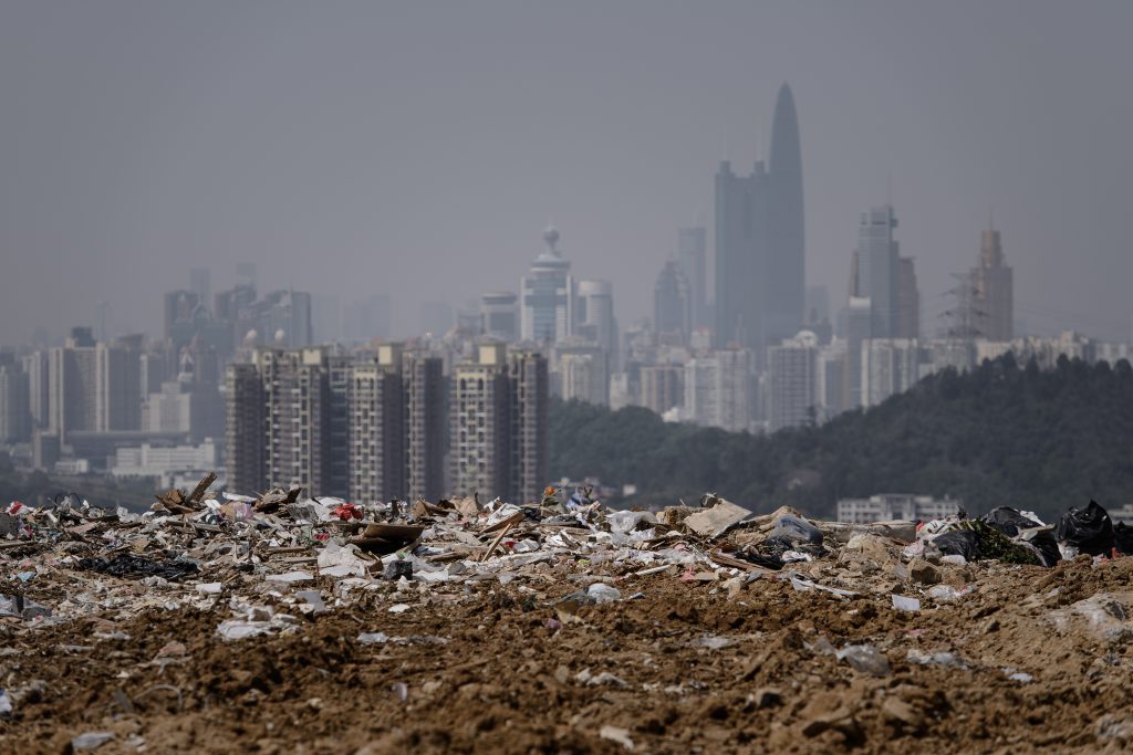 TO GO WITH: Lifestyle-Hong Kong-Environment-Waste by Laura Mannering This picture taken on March 6, 2013 shows a landfill in the new territories of Hong Kong as the Chinese city of Shenzhen looms in the background. Official data shows that the city generates about 19,000 tonnes of solid waste every day, with 9,100 tonnes dumped into landfills -- two thirds of it domestic waste. Only 52 percent of total waste is recycled in a city that produces an average of 921 kilograms of rubbish per person per year, which is more than twice the amount compared to Japan (410kg) and South Korea (380kg), according to the Organisation for Economic Cooperation and Development. AFP PHOTO / Philippe Lopez / AFP PHOTO / PHILIPPE LOPEZ
