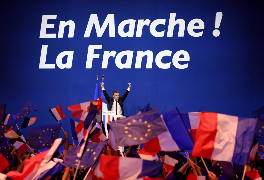 French presidential election candidate for the En Marche ! movement Emmanuel Macron waves at the audience during a meeting at the Parc des Expositions in Paris, on April 23, 2017, after the first round of the Presidential election. Centrist Emmanuel Macron and far-right leader Marine Le Pen emerged as the projected winners of a nail-biting first round presidential vote in France. / AFP PHOTO / Eric FEFERBERG
