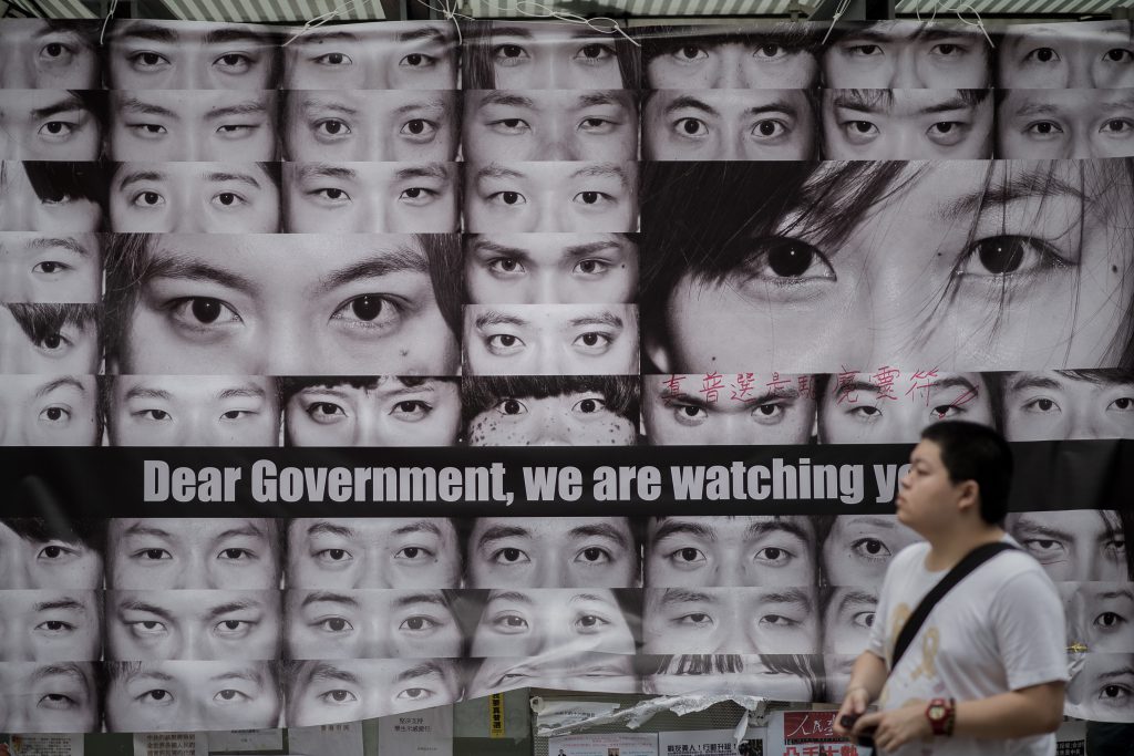 Posters showing pictures of the eyes of pro-democracy protesters are displayed in the Admiralty district of Hong Kong on November 11, 2014. Hong Kong bailiffs and police are planning to take action at pro-democracy protest sites in the city, as pressure grows on demonstrators to leave, the government said. AFP PHOTO / Philippe Lopez / AFP PHOTO / PHILIPPE LOPEZ