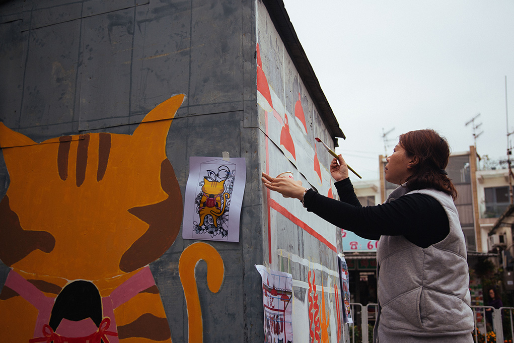 義工一大早來到錦田村，為排檔壁畫上色。