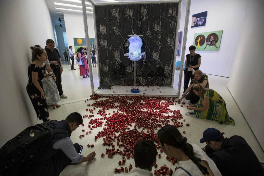 動畫顯示屏背面，有一個轉動的透明塑膠頭像，和一堆發條金牙公仔，引起觀眾注意。