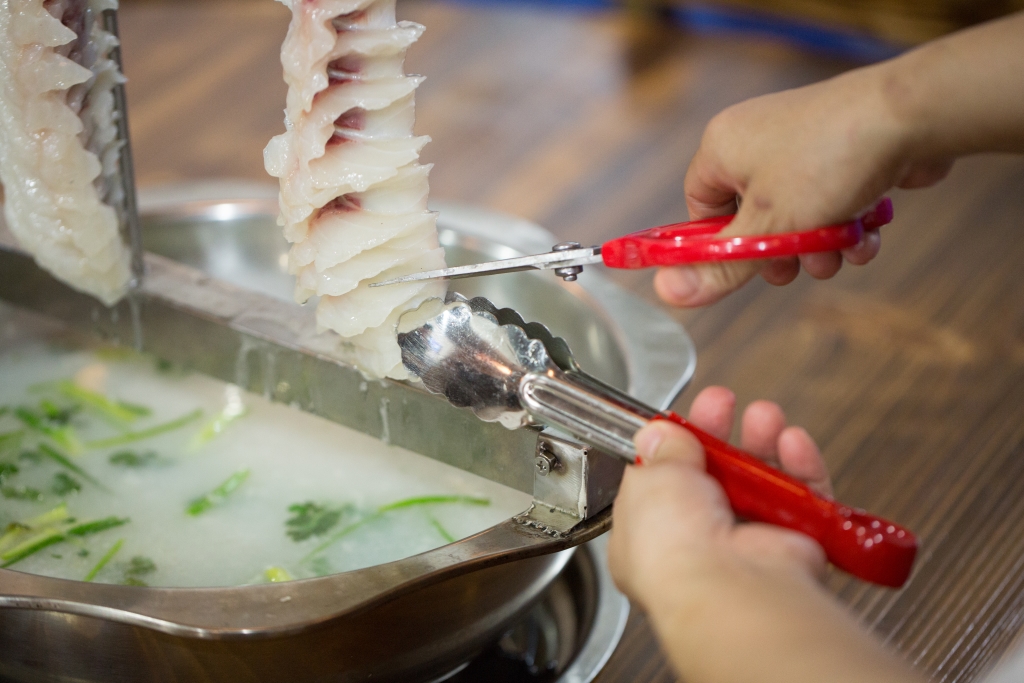 新鮮河魚吊放在鍋上，邊剪邊吃，放進粥底火鍋中涮燙，粥水絕對是精華。