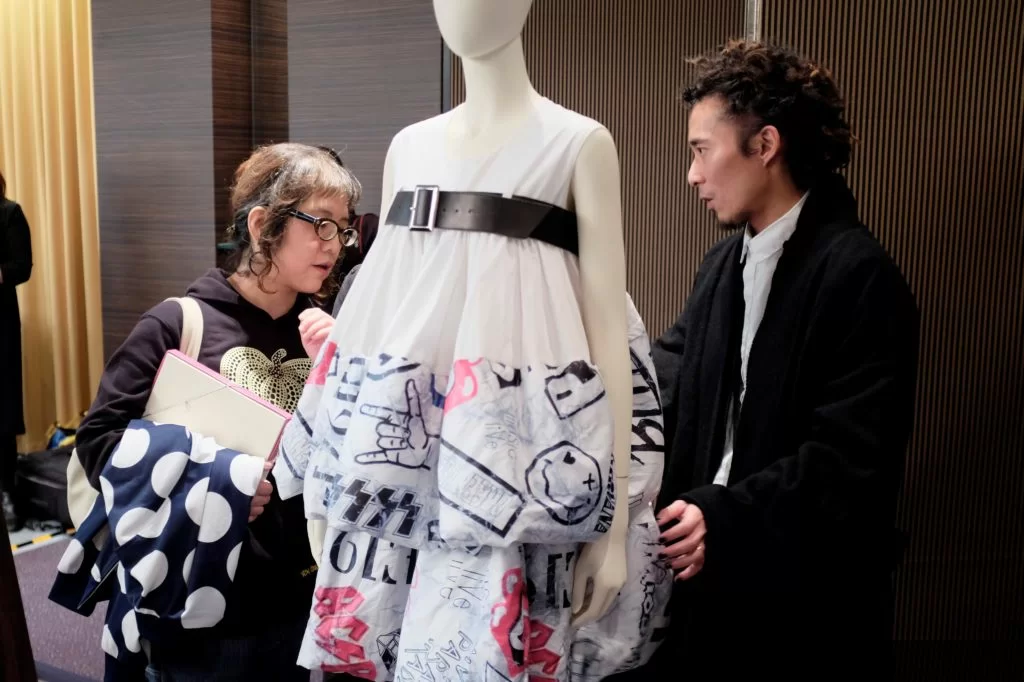楊展（左）正向來訪者介紹他的最新系列FW18，系列融合了日本藝伎和搖滾的意念。