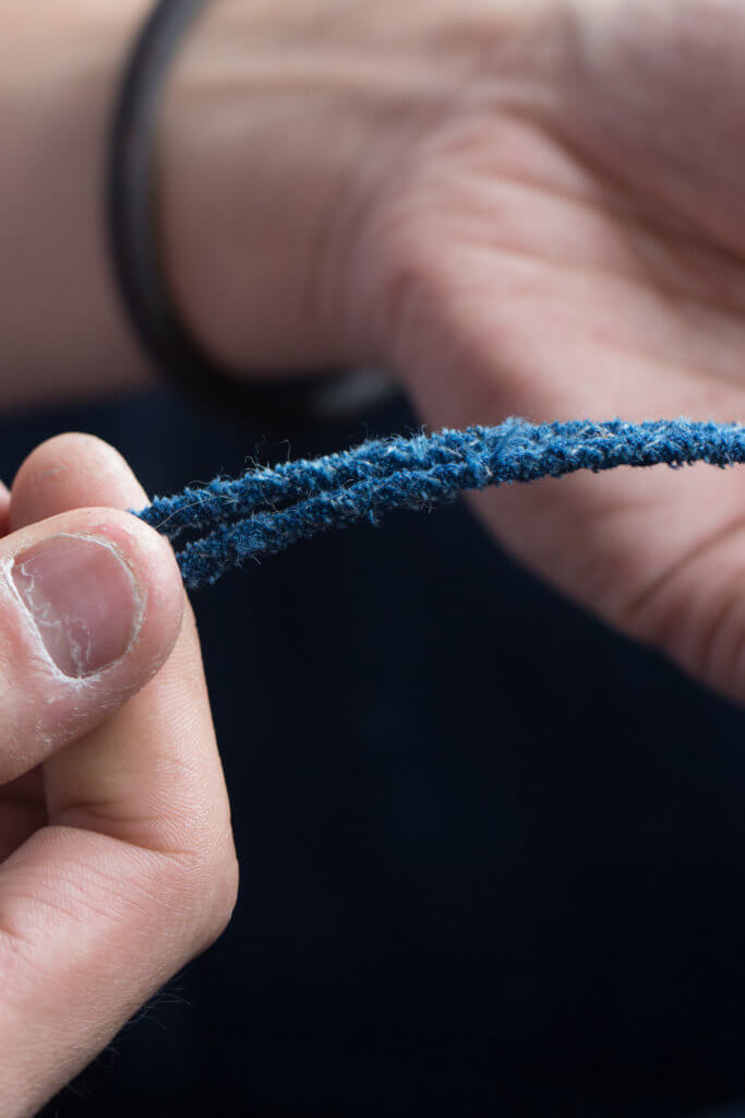 繩子以藍染古布及四股圓編手法編製，柔韌而不斷，編一條古繩約兩個多小時。