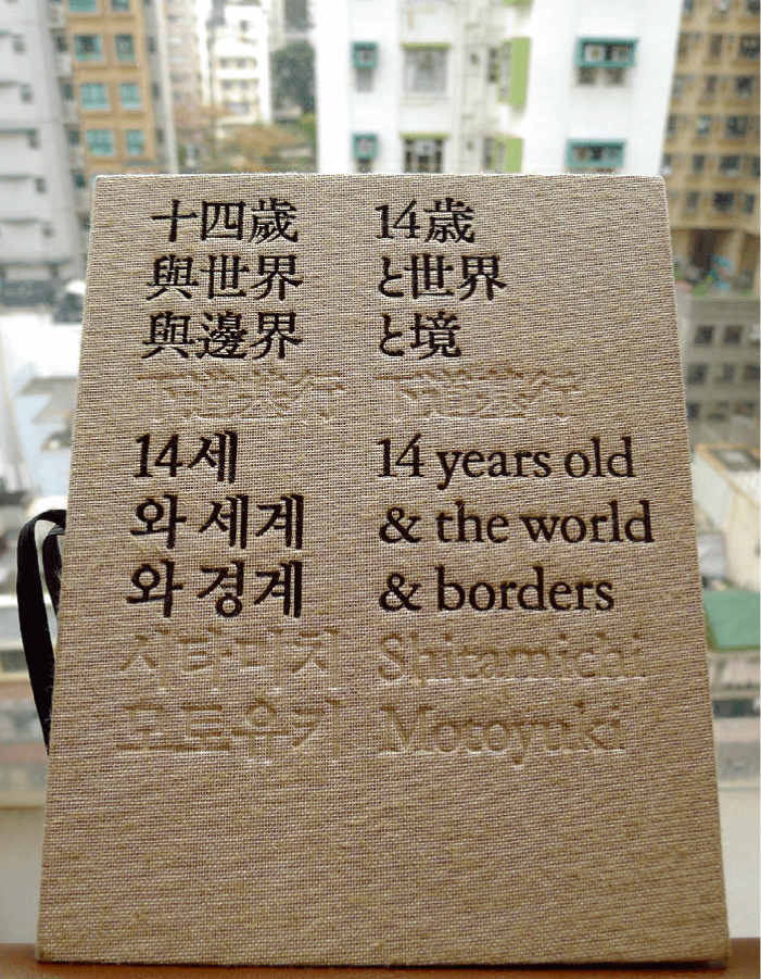 下道基行《十四歲與世界與邊界》的封面，背後是香港的住宅大廈，大館當代美術館及Michi Laboratory出版，2019年。（圖片由作者提供）