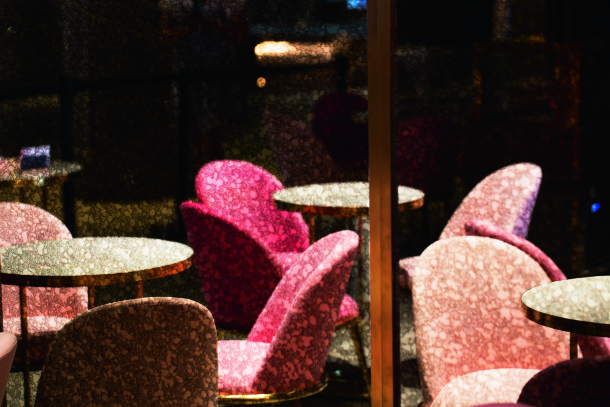 放在門前的絨製座椅顏色，正呼應着主廳花海牆上的山茶花。