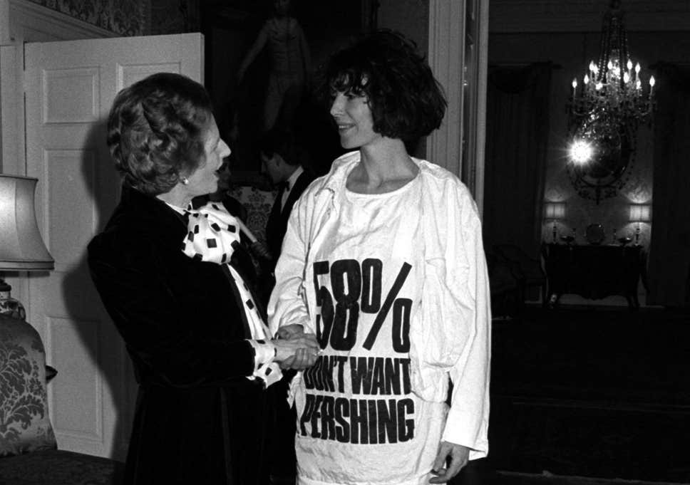 英國設計師Katharine Hamnett功不可沒，她穿上寫着”58% don’t want Pershing”長版T恤會見戴卓爾夫人的時候，除了表達反對英國政府欲同意美國在歐陸設置導彈的想法，亦間接將帶有意識的標語設計與時裝赤裸融合。