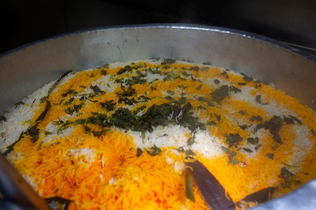 ）印度香米用多種香料煮 成，包括月桂葉、班蘭葉、肉 桂、丁香、小荳蔻、薑、蒜 頭、洋葱等。米粒沾上香料顏 色後，會變成橙橙黃黃的。