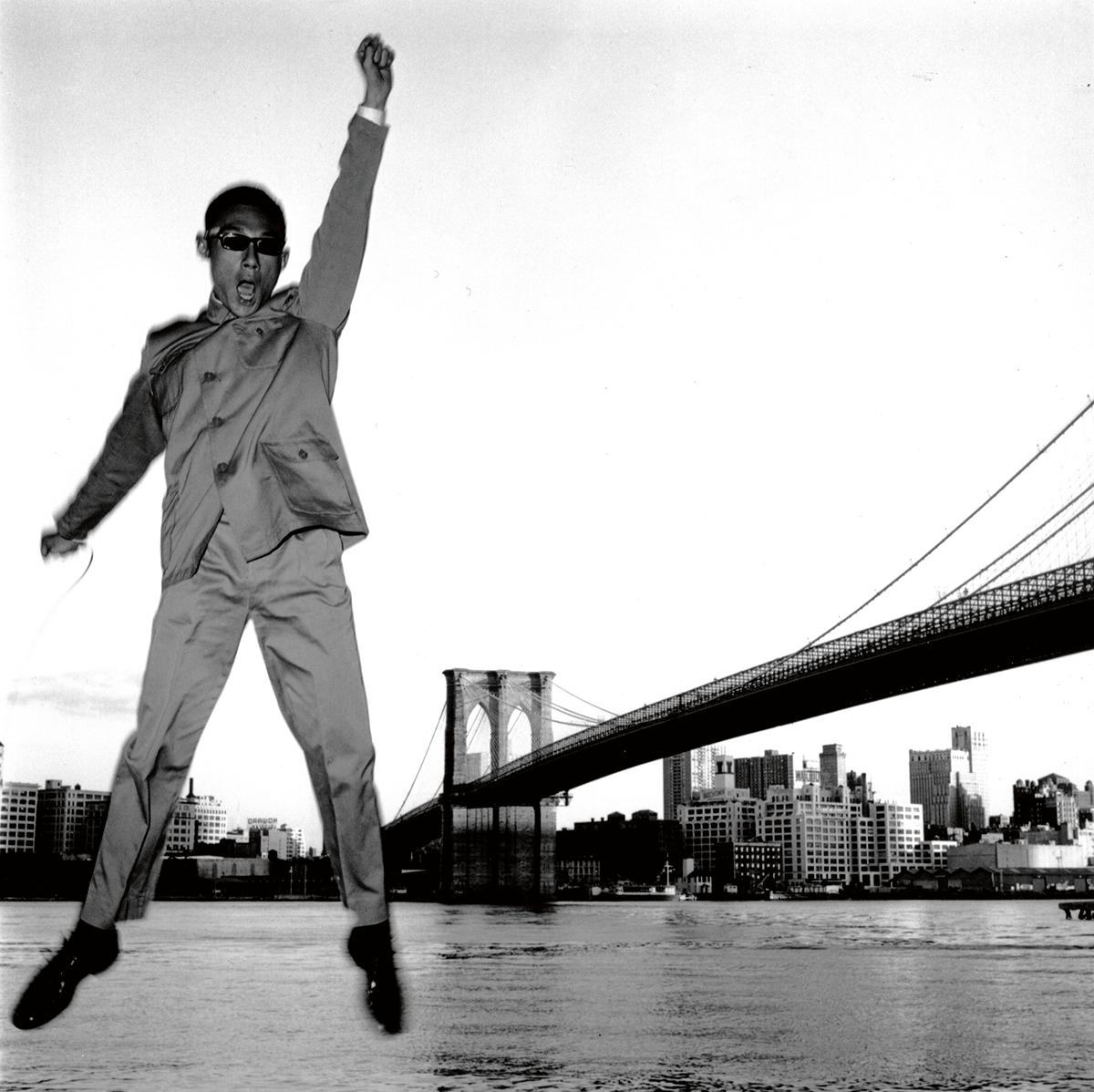     一九七九年在布魯克林大橋拍攝的照片，可見他手中拿着快門線，彷彿在強調這一切都只是一場表演。