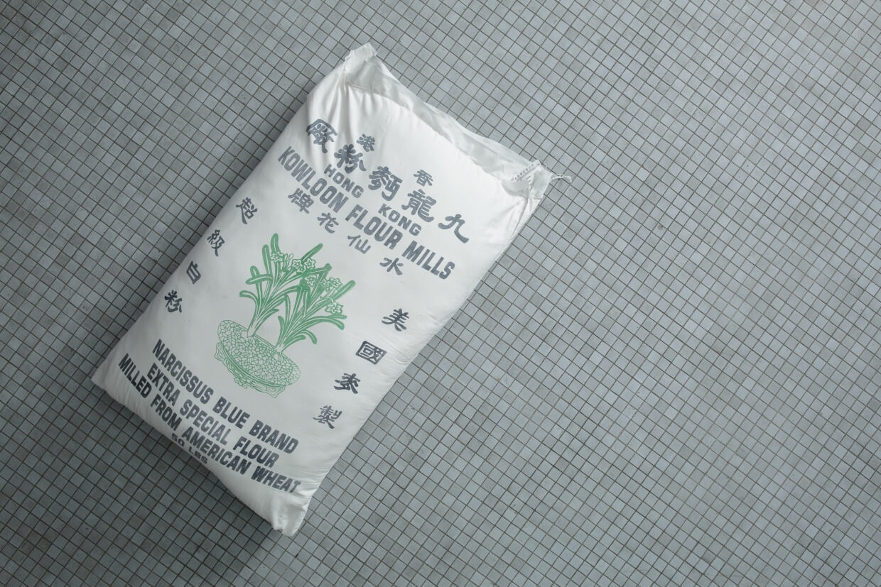 一袋麵粉足有50磅，袋上繪有清雅花兒作記認，特級低筋麵粉的代表圖案便是水仙。