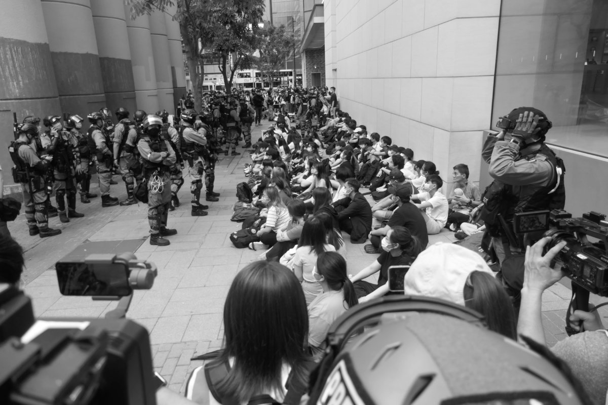 2020年5月27日，香港銅鑼灣希慎廣場後地面、港鐵大型石屎通風口附近，就國歌法立法示威的年輕示威者被拘留，排成一線。（照片由作者提供）。