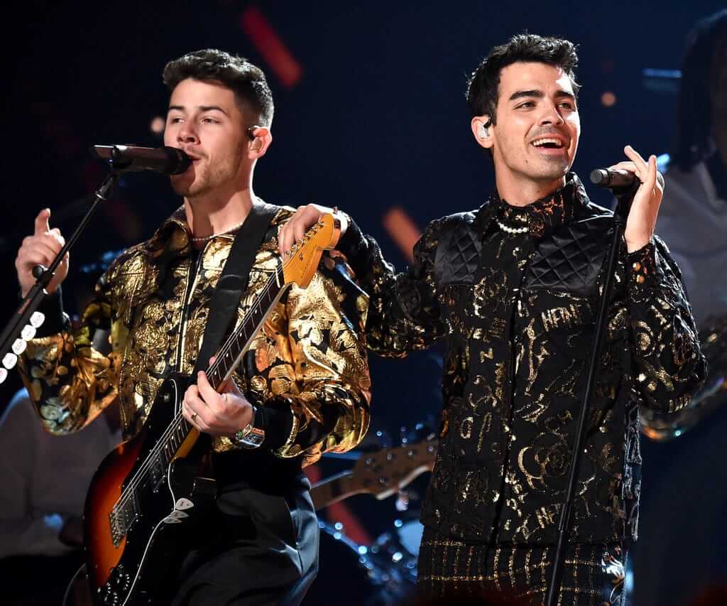 Joe & Nick Jonas兩兄弟同樣在格萊美獎的舞台上，以黑金造型配短珍珠項鏈。