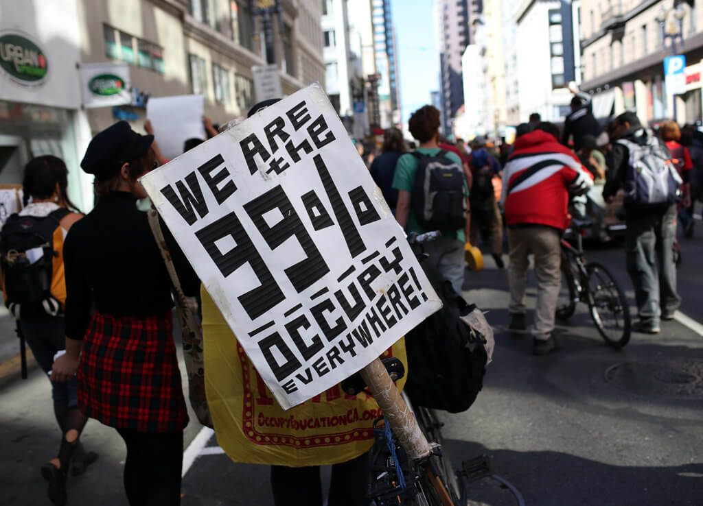 SAN FRANCISCO, CA - SEPTEMBER 17: An Occupy Wall Street protestor holds a sign during a demonstration on September 17, 2012 in San Francisco, California. An estimated 100 Occupy Wall Street protestors staged a demonstration and march through downtown San Francisco to mark the one year anniversary of the birth of the Occupy movement.   Justin Sullivan/Getty Images/AFP