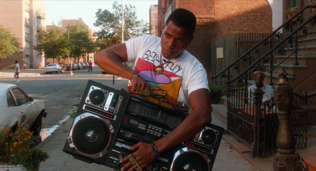 《Do the Right Thing》（1989）劇照，圖中為主角Radio Raheem（Bill Nunn飾）。他常提着其Promax J1 Super Jumbo Boombox通街跑播歌。 