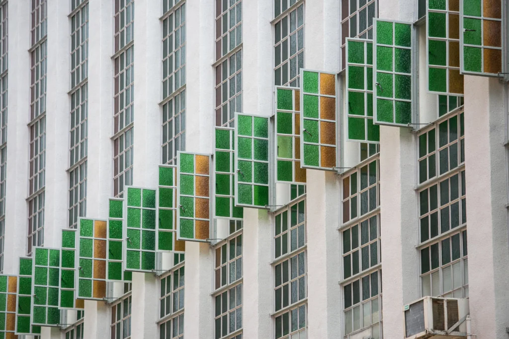 彩色玻璃窗打直伸展，橫跨幾層高，抵銷長形建築的笨重感。