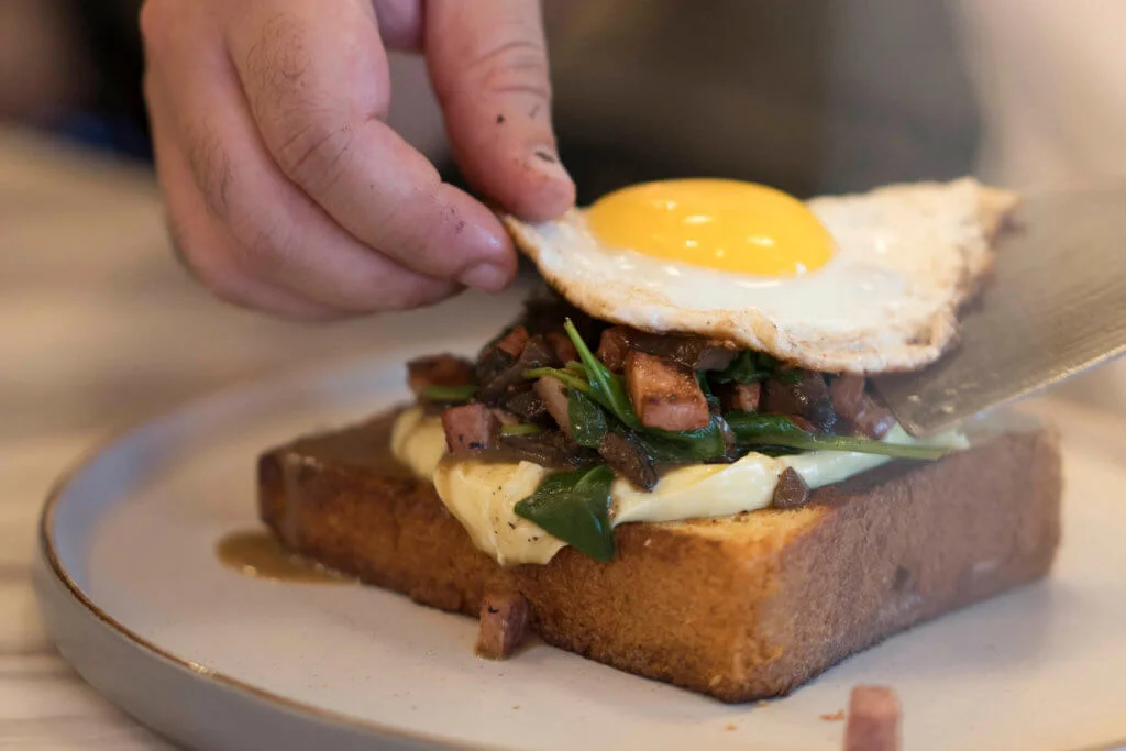 個周末，專程攀爬斜路來到伊 利近街食早餐的人都很多，人龍太長，老闆要借用毗鄰酒吧的空 間，在日間容納更多客人。等待餐點時，看着店員俐落地在吧枱上以各式餡料砌疊、出餐。