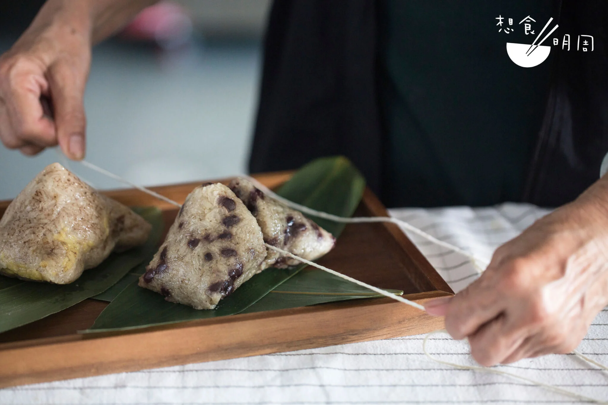 烚好的糭子待大家分吃享用。正想尋利刀來切，「阿姨」立即發揮長輩的智慧，直接用剛拆開糭子剩下的棉繩，拉成一圈收緊𠝹開糭子。手法俐落，切面工整，今個端午節來試一試吧。
