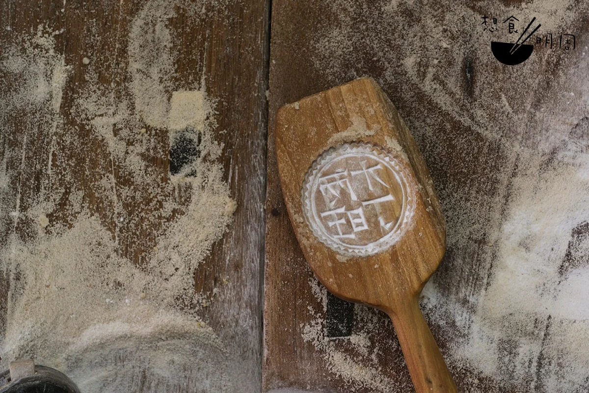 先在木模內撲一層米粉，以便米餅脫模。