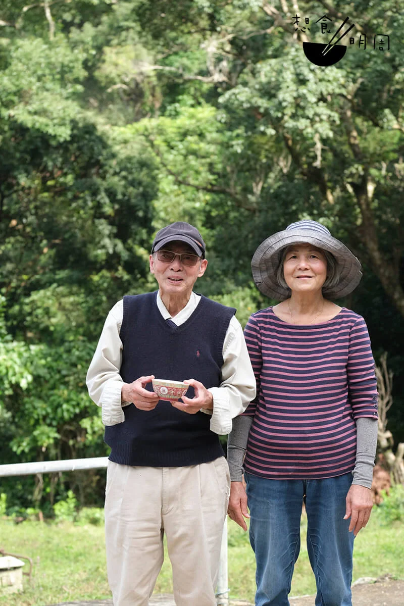 楊廣華（左），早年偕同妻子曾桂英（右）離鄉遠赴英國打工，在倫敦教燒臘及打麵，不足兩年便賺到本錢在家鄉修建楊宅，樓頂大字「一九六七」正是修建年分。千禧年前已常回港過冬，既愛香港的暖和，亦念想香港的友伴。他也常記掛着谷埔的美麗，久不久便會回來老宅，但礙於交通不便亦難長居。