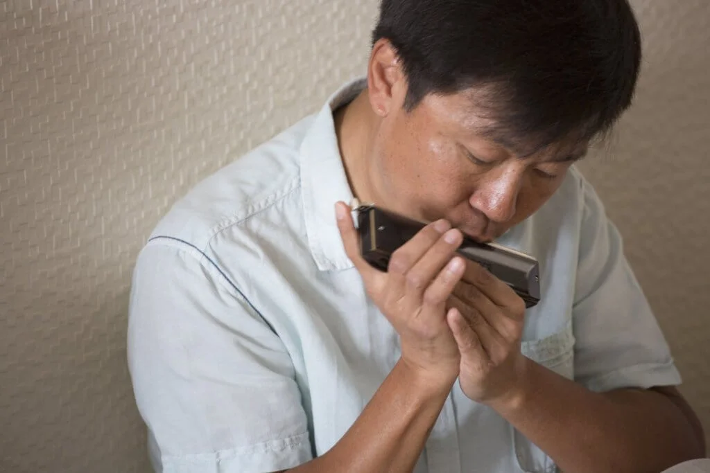 何百昌的人生，游走於口琴和手術刀之間。