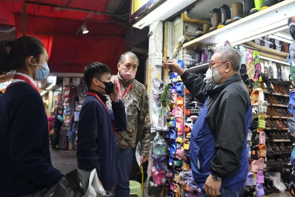 中學組參加者在大埔街頭尋找商戶「領養」富貴竹，並在過程中與街坊攀談。