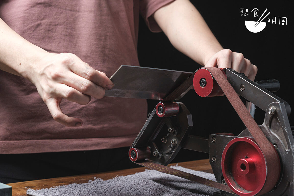 專業磨刀師傅會用沙帶機快速修正刀具。
