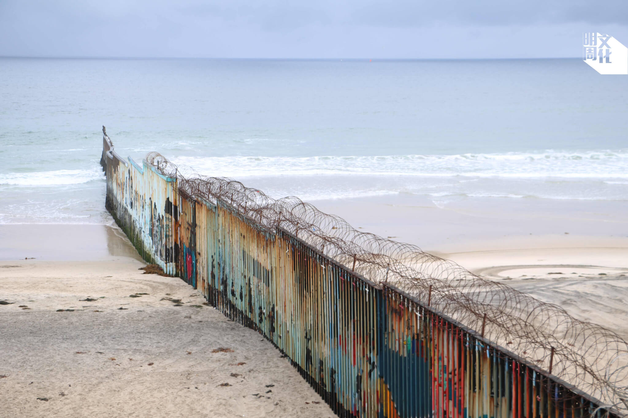 美墨邊境圍牆延伸至太平洋。墨西哥蒂華納的一側繪滿了壁畫。