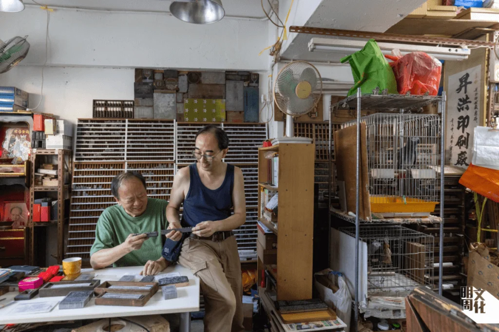 梁氏父子檔，現在以傳承活字印刷工藝為己任。一對養了超過二十年的非洲鸚鵡，陪伴他們開工，增添生氣和樂趣。
