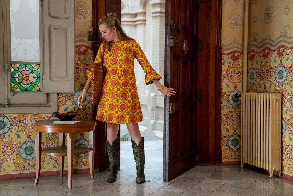 她的巴塞羅那造型搭配印花 La DoubleJ 束腰連衣裙和 Golden Goose 靴子，充滿了 60 年代的魅力。