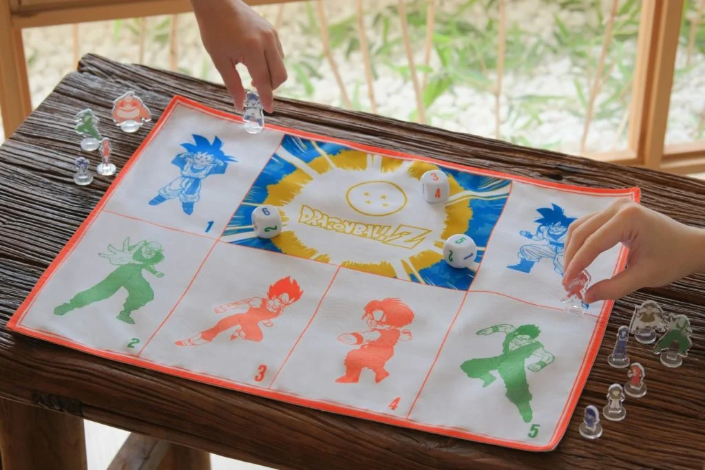 派對桌上遊戲戲墊上印有悟空、悟天、比達等角色，棋子包括有魔人布歐等角色，玩法簡單，可12人同時參與遊戲。