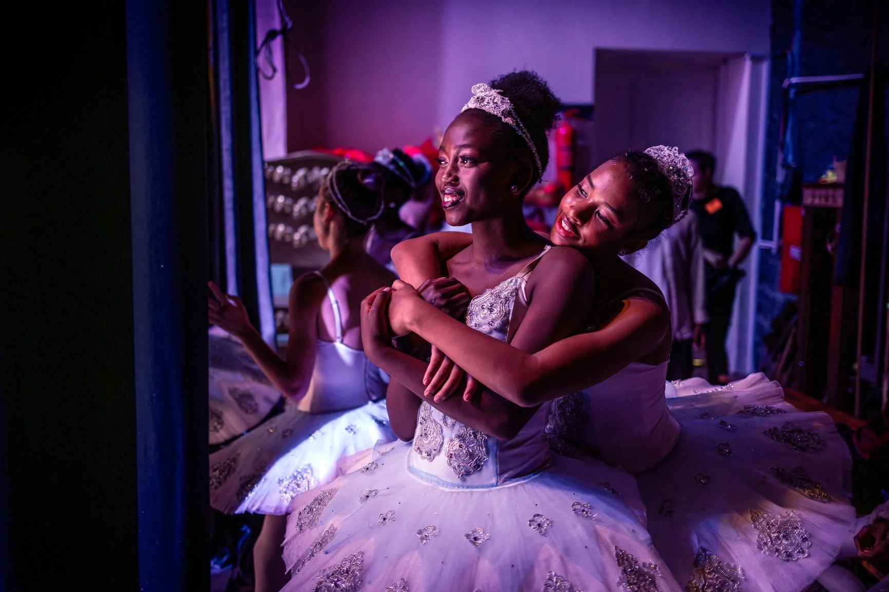 舞者Pauline Okumu（左）和Natalia Como（右）在肯亞國家劇院的後台相擁，她們正出演經典芭蕾舞劇《胡桃夾子》。二人來自肯亞舞蹈中心（Dance Centre Kenya），這所舞蹈學校不論學生能否支持訓練費用，一直培育具天賦的舞者，多年來已影響許多出身貧困而有抱負的年輕人。照片攝於十二月。（LUIS TATO / AFP）
