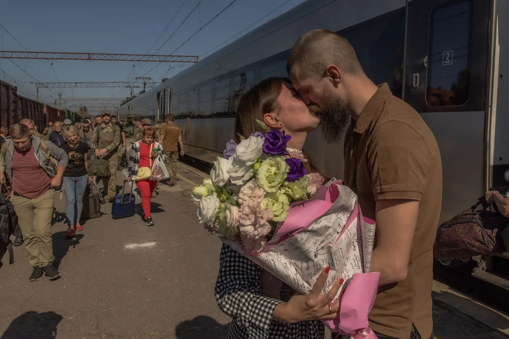 烏克蘭士兵Oleksiy的妻子Maryna從基輔乘搭火車到克拉瑪托爾斯克（Kramatorsk）探望丈夫，二人在火車站接吻。照片攝於九月。（ROMAN PILIPEY / AFP）