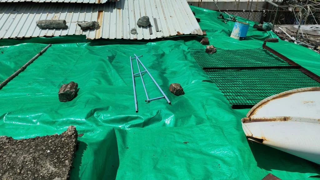 Candy和丈夫把香港紅十字會送贈的大帆布鋪在屋頂,解決燃眉之急。