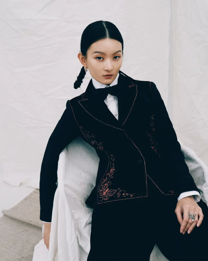 BLAZER IN Embroidered wool and silk PANTS IN Cupro velvet BLOUSE IN WHITE COTTON BLACK SILK BOW TIE DIOR TRIBALES EARRINGS PAPILLON DE NUIT RING 