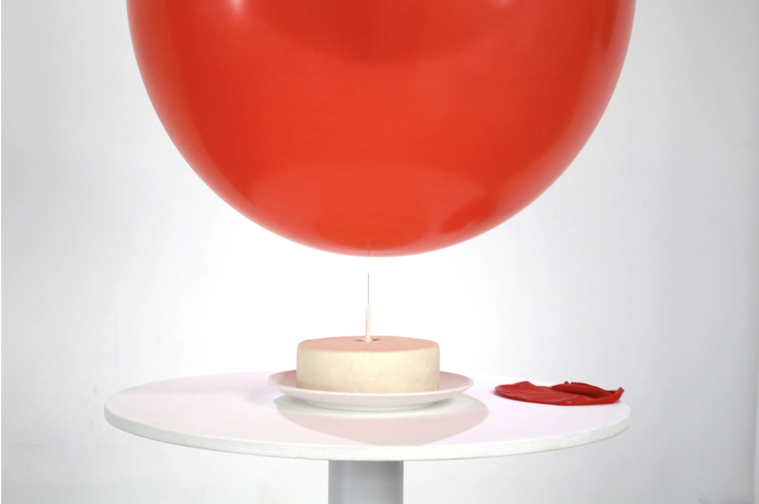 卓思穎作品。《破・快樂》，以一個不停在針上充氣和放氣的氣球裝置，營造對生日徘徊於期待與失望之間的壓力。（定製電子、氣泵、氣球、針、木、糖霜，圖片由藝術家提供。）