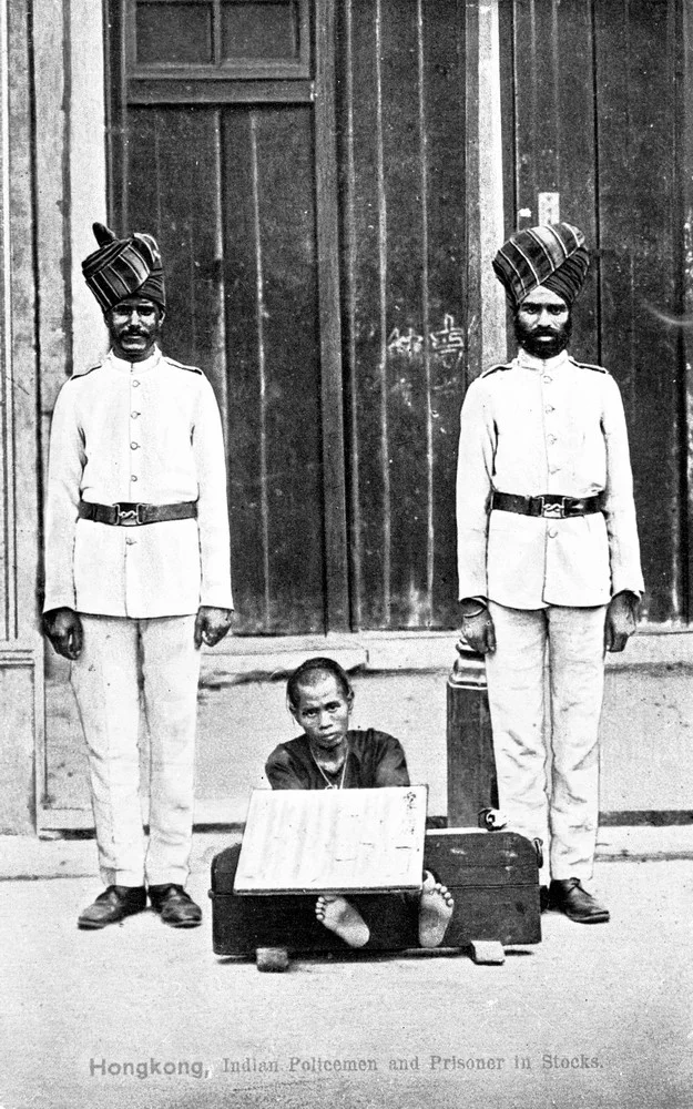 一九二○年代，印度警察與扣上腳枷的犯人。（政府檔案處圖片）
