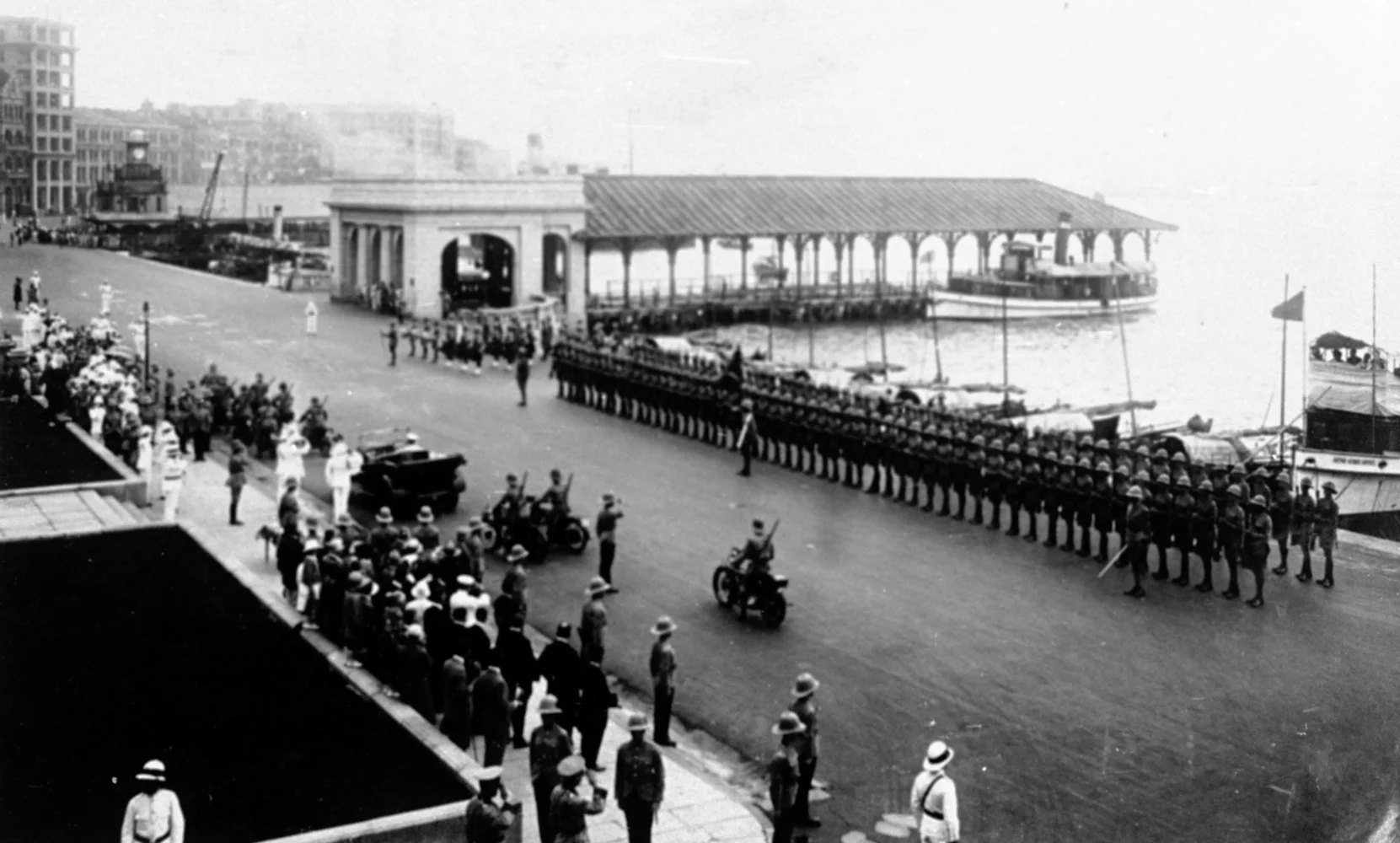 一九二八年，慶祝英皇佐治五世壽辰，隊伍在皇后碼頭一帶，干諾道中巡遊。（政府檔案處圖片）