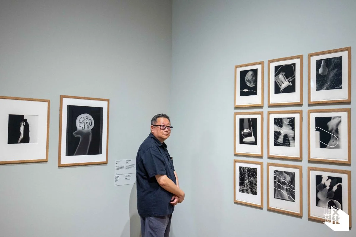 香港國際攝影節策展組成員黃啟裕（圖）引領記者觀看黑白攝影展覽，闡述由美國攝影師Man Ray創作的《電力—為巴黎配電公司拍攝的九張實物投影照片》（1931）如何使用「實物投影」Photograms）的技術。