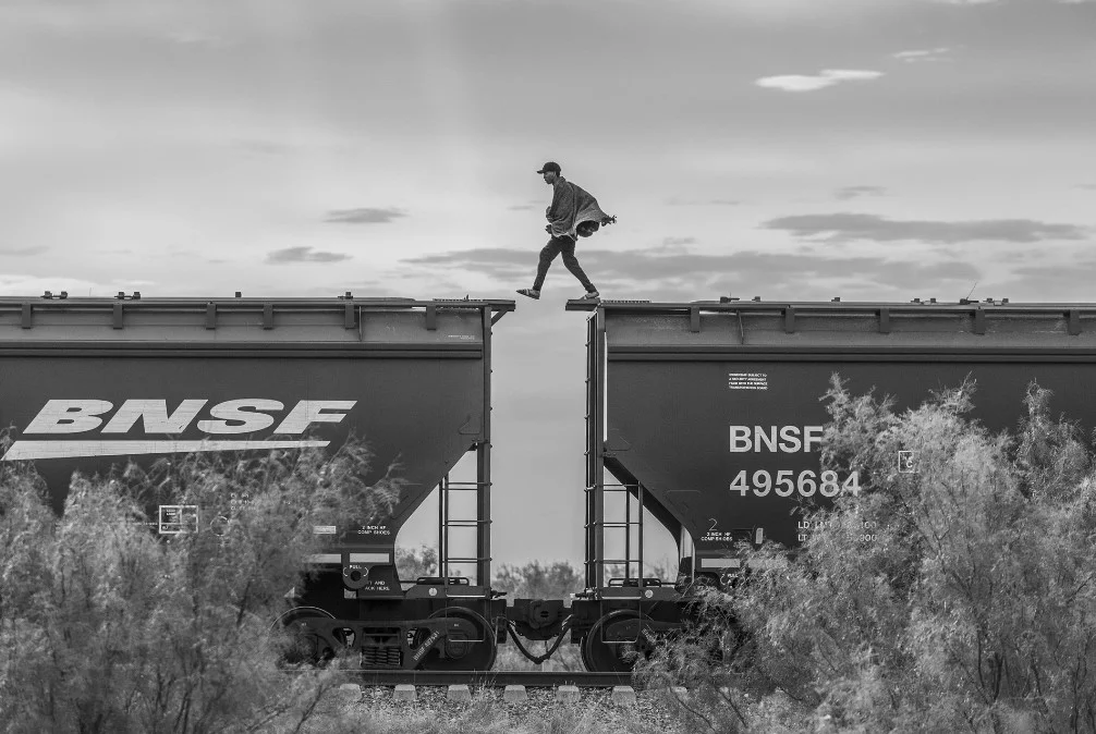 一名移民者在墨西哥走在被稱為「野獸（The Beast）」的貨運列車上，缺乏資金的移民者或尋求庇護者往往會使用貨運列車幫助自己抵達美國邊境，但這種方法非常危險，多年來已有數百人跌入鐵軌死亡或導致傷殘。