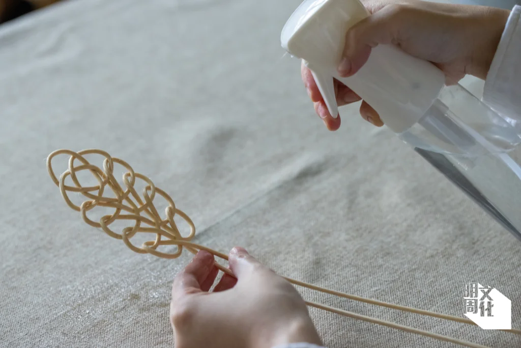 步驟四：編織過程中適時噴水，保持藤的柔韌度，便於屈曲。