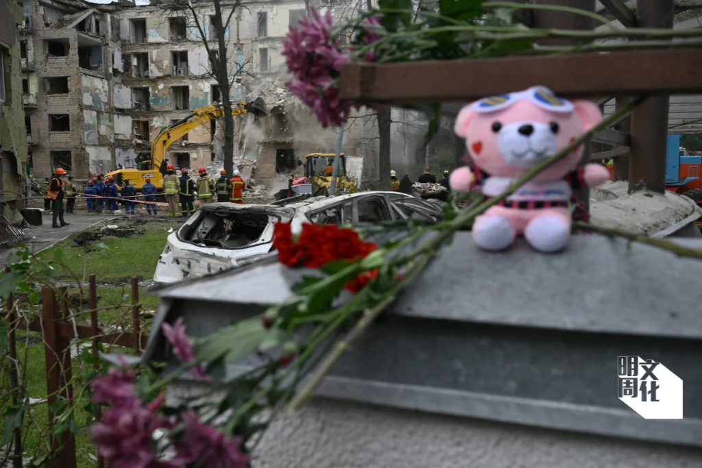 俄烏戰爭爆發逾兩年，照片拍攝於今年六月二十四日，救援人員正在清理基輔一棟住宅大樓，人們擺放著鮮花和玩具，以紀念罹難者。就在拍照前一天，俄羅斯飛彈襲擊了基輔這棟大樓，造成十人死亡。（法新社）