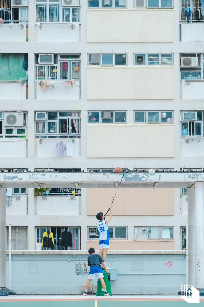 在彩虹邨的七色籃球場上，少年們設法將籃球從頂蓋上拿下來。