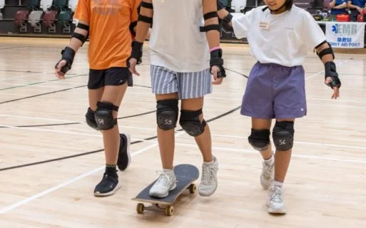 學員們穿戴運動護具裝備,躍躍欲試地踏上滑板,輪番練習基本平衡動作。