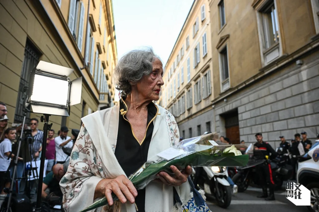 Giorgio Armani 宣布逝世後，一名女子手持鮮花，旁邊寫有「親愛的Giorgio 」的卡片，出現在米蘭公司總部外。