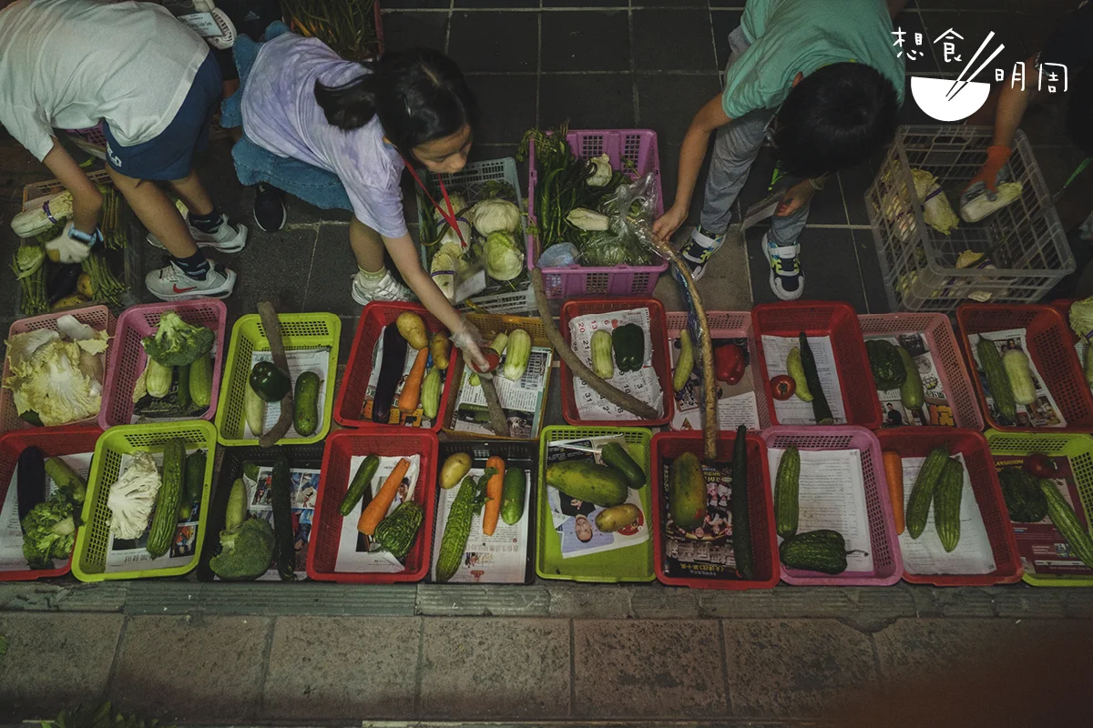 親子分組後，會與義工一起把從街市各個檔口收集回來的菜蔬，進行簡單目測檢驗狀態，然後交由小朋友幫忙平均分派到各個受惠者的菜籃。
