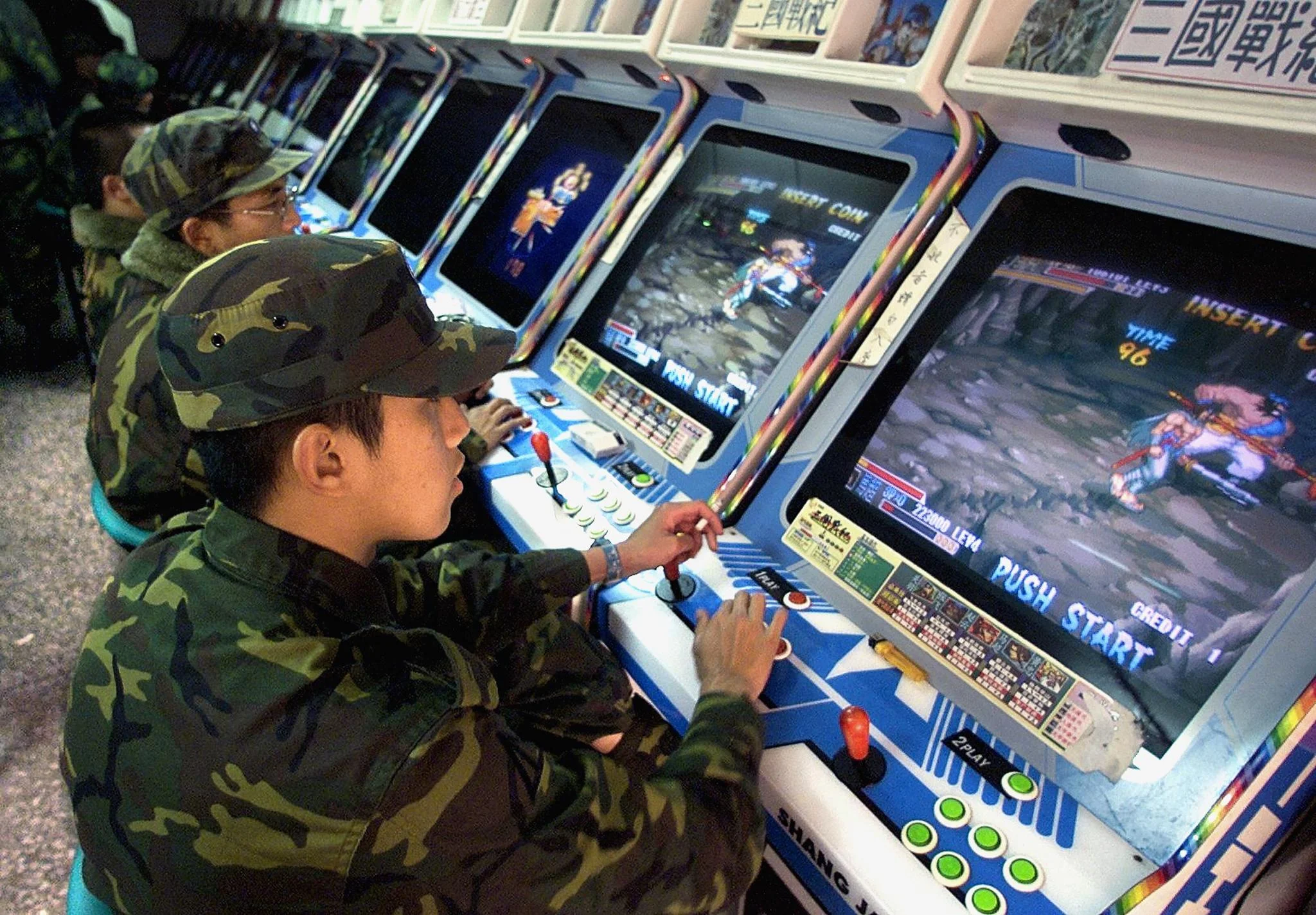 二○○○年金門，休假士兵在街機舖打機。