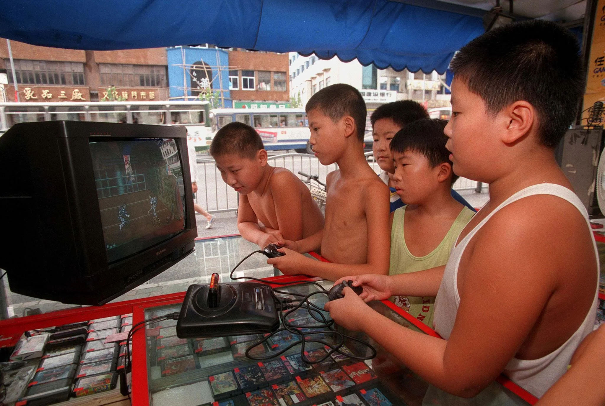 一九九八年上海，中國小朋友暑假時 聚在遊戲機舖玩家用遊戲機。