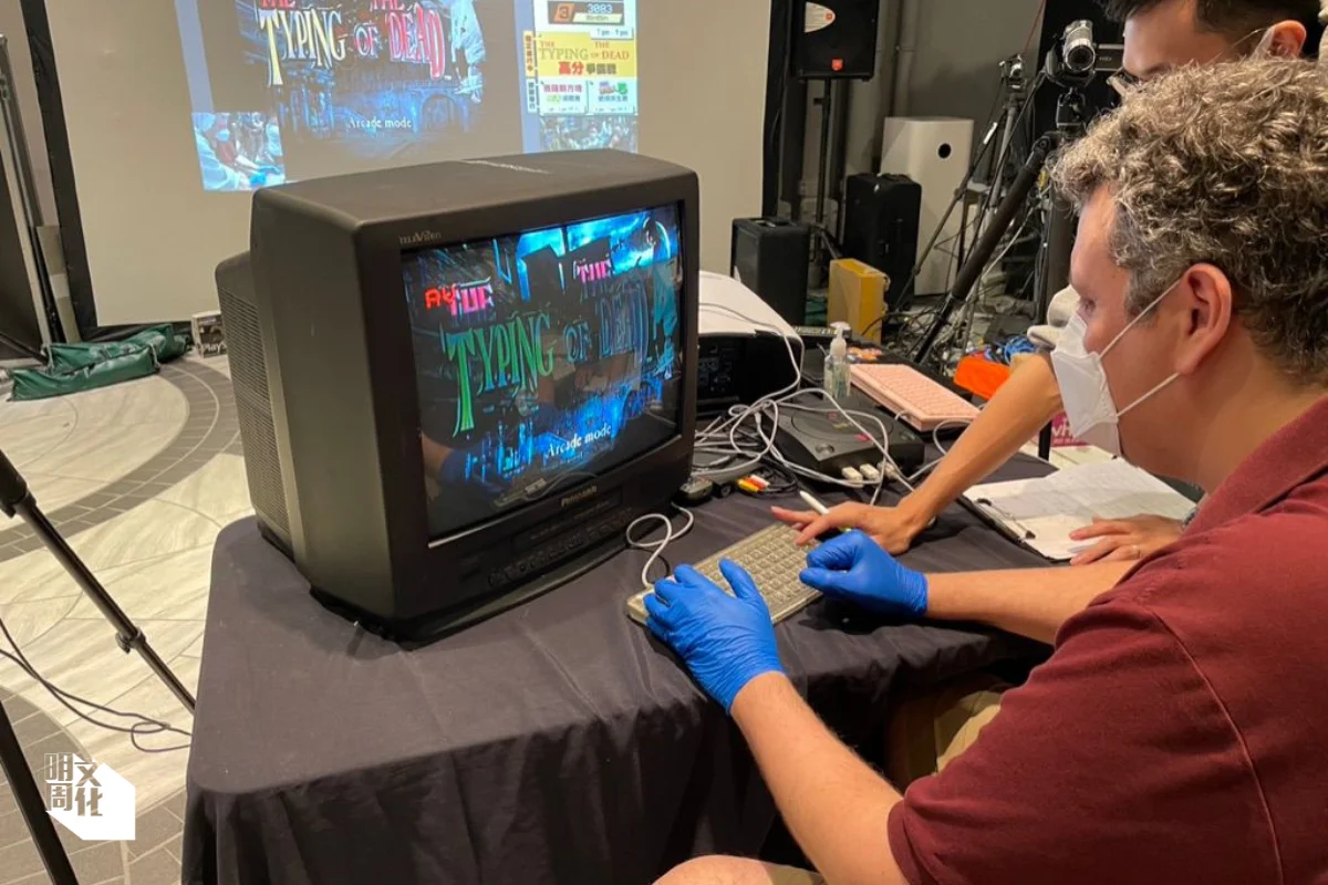 ）另一展覽參加者 遊玩《死亡鬼屋打字 版》，玩家需輸入單字 或詞組，以發出光線槍 射擊喪屍或敵人，遊戲 甚具教育意義，提升玩 家的打字技巧。