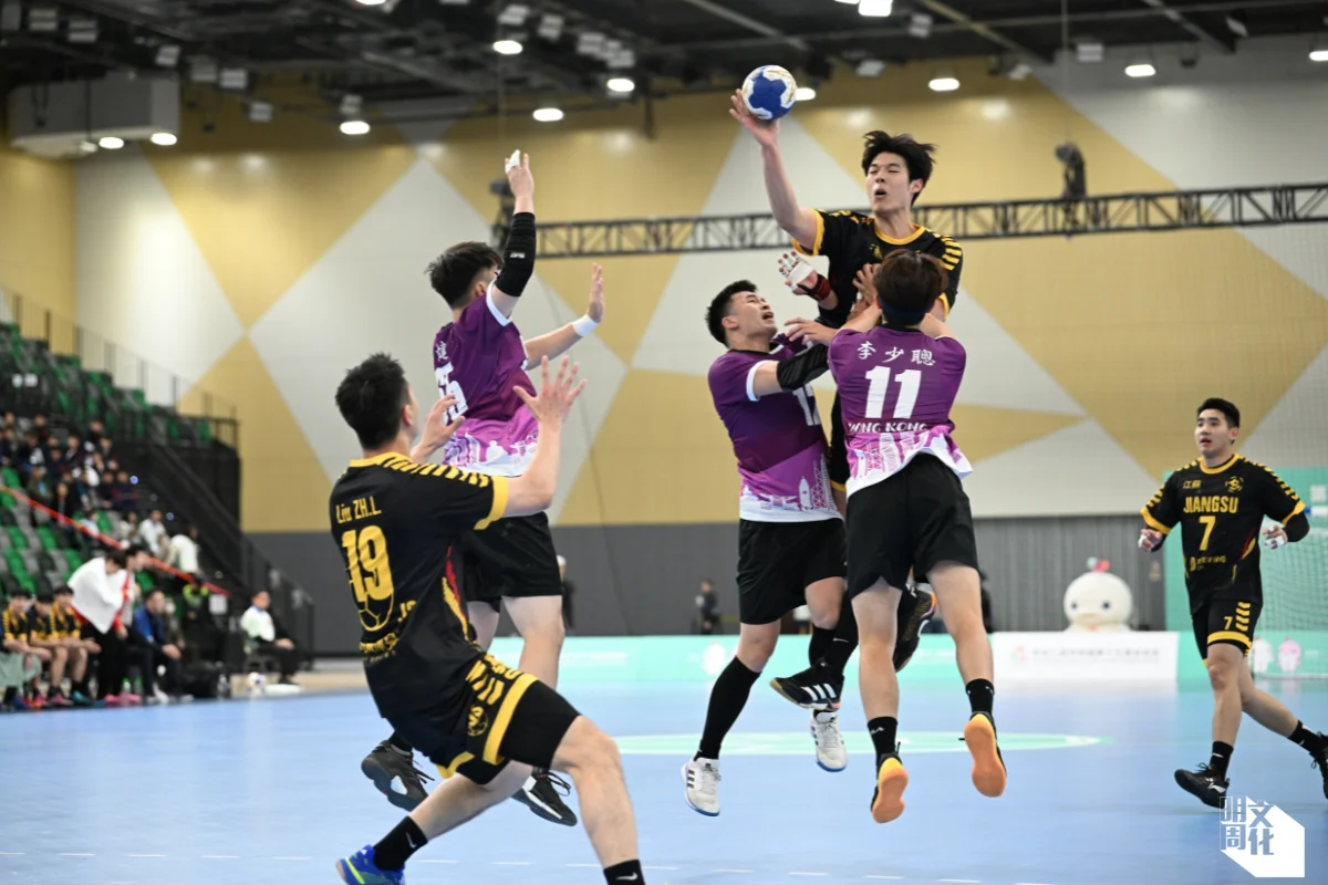 二月在啟德舉行全運會測試賽，四隊當中，港隊奪銀，負江蘇八分。港隊（紫衫）和江蘇隊（黑衫）在體型上有明顯差距。 （由中國香港手球總會提供）